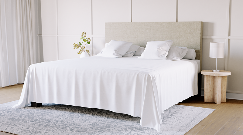 King size metal platform bed with a beige headboard and a white flat sheet draped over the bed and hanging down to the ground.