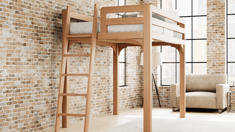 Light colored queen size Wood Loft Bed for Adults in an urban loft-style apartment with light exposed brick walls and a lot of natural lighting, seen from the foot of the bed frame where the ladder is attached at a slight angle toward the lower left-hand corner of the bed.