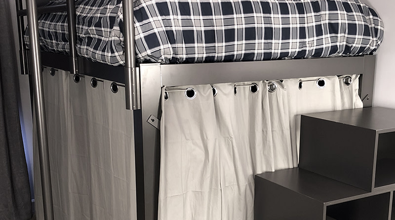 A curtain accessory attached to a black Adult Loft Bed