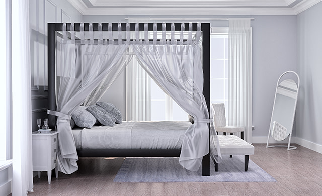 A charcoal Wyoming King size Canopy Bed with white drapes in a light, sparsely decorated but upscale bedroom. Seen directly from the right side at a slight distance.