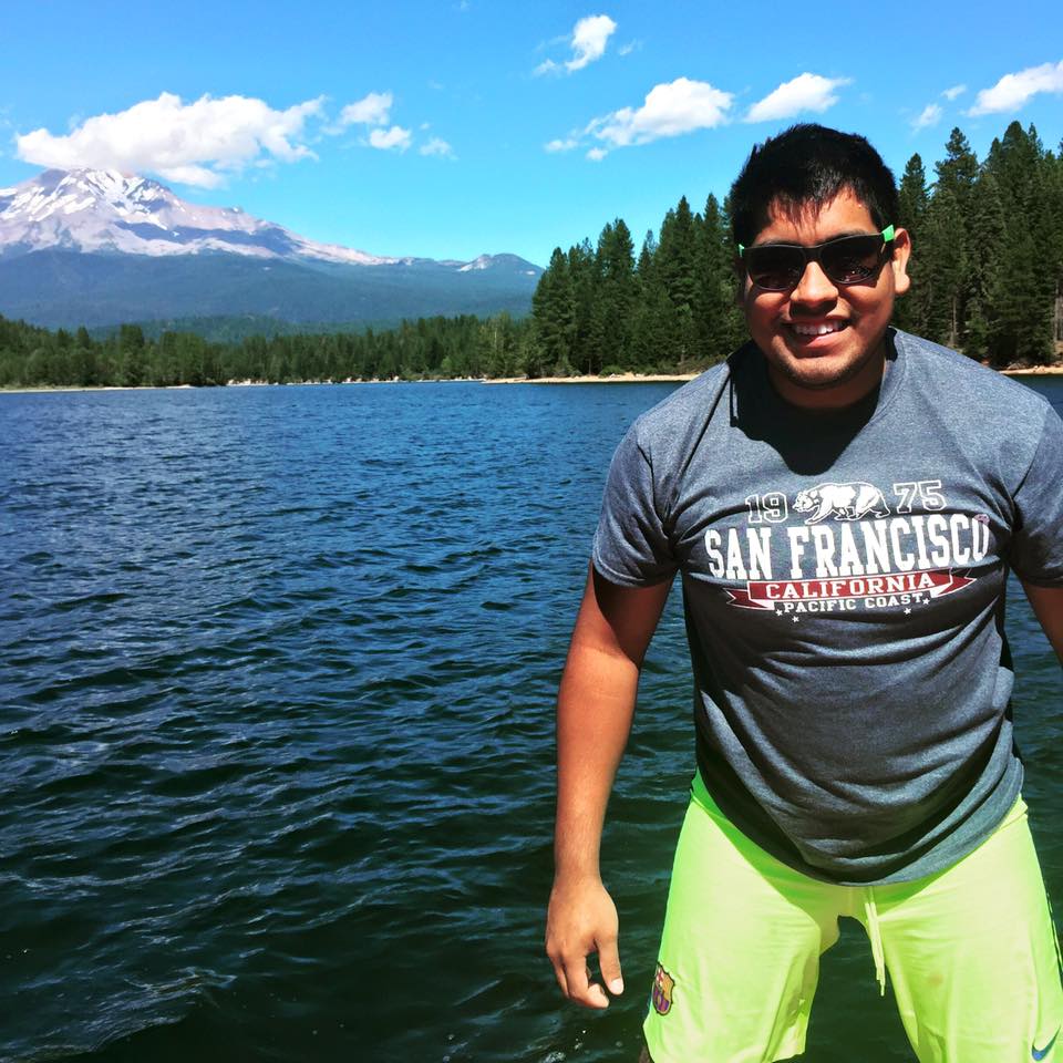 Jesse in front of lake + trees