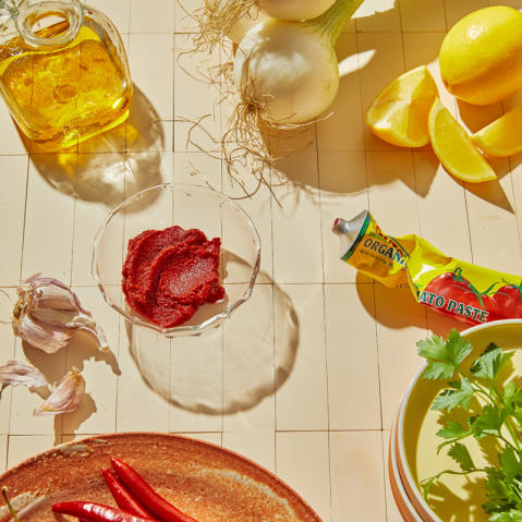 Tomato paste, olive oil, lemons, and other produce on a countertop