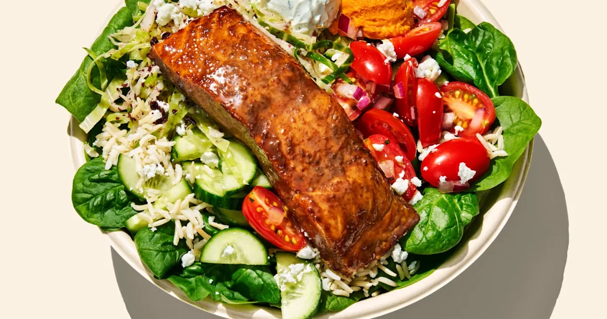 CAVA Salmon and Strawberry Sesame Bowl with glazed salmon, rice, greens, vegetables, dips, feta, slaw, and dressing