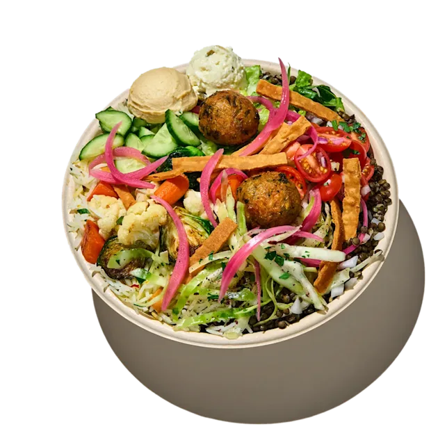 CAVA Falafel Crunch Bowl with falafel, vegetables, dips, greens, rice, lentils, pita crisps, and skhug