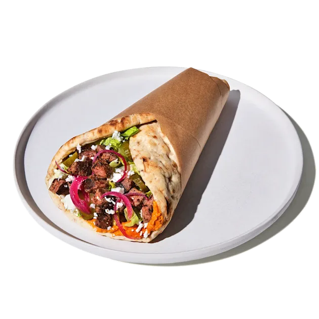 CAVA Steak and Feta Pita with grilled steak, dips, feta, pickles, romaine, and dressings