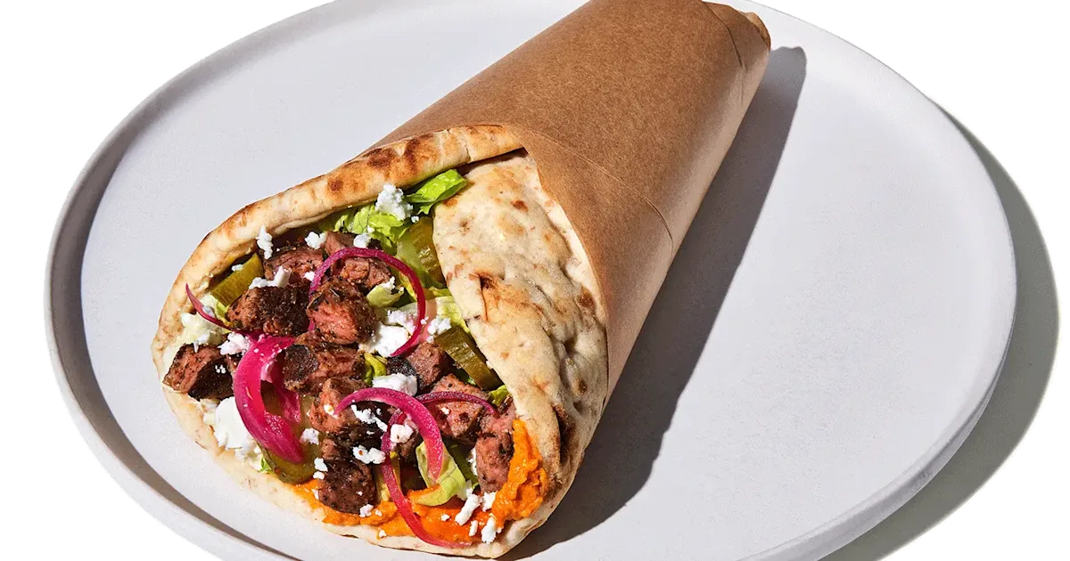 CAVA Steak and Feta Pita with grilled steak, dips, feta, pickles, romaine, and dressings