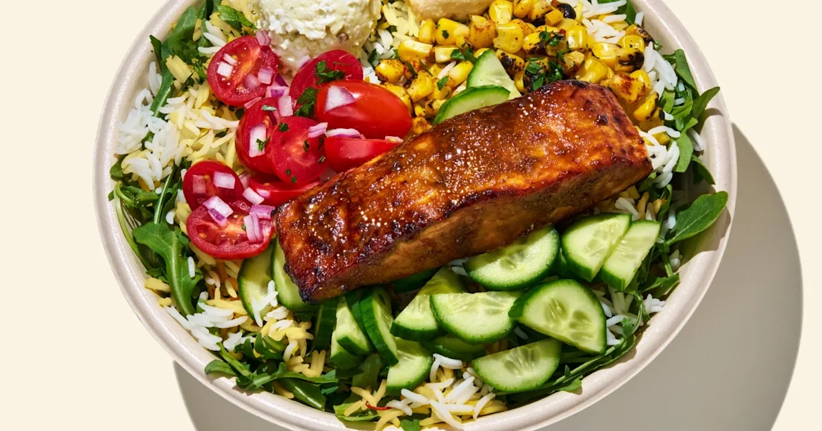 CAVA Salmon and Yogurt Dill Bowl with glazed salmon, rice, greens, dips, corn, vegetables, and dressing
