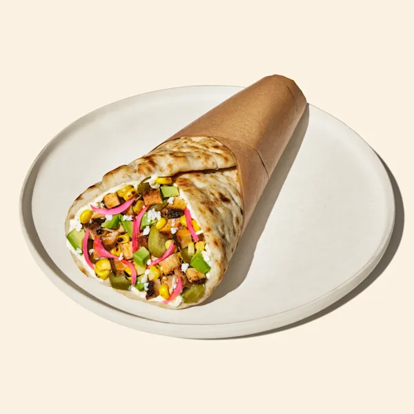 A CAVA Spicy Chicken and Avocado pita on a plate