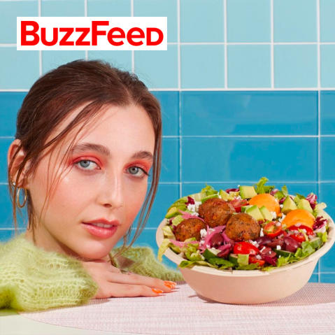 Buzzfeed logo on a photo of Emma Chamberlain posing with her custom bowl