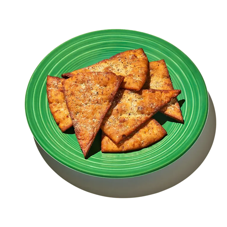 Sumac Sour Cream and Onion Pita Chips on a green plate