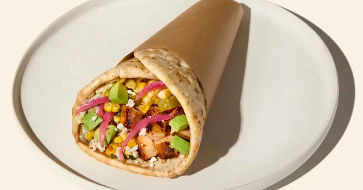 CAVA Spicy Chicken and Avocado Pita with harissa honey chicken, avocado, cheeses, pickles, corn, onions, and vinaigrette