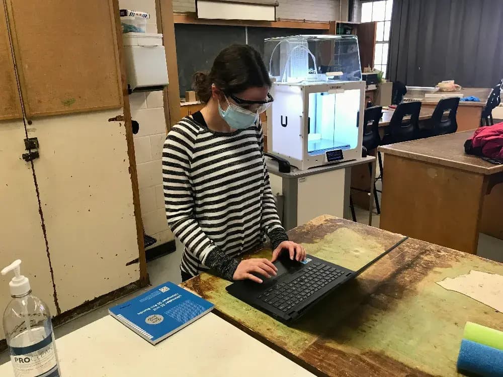 Olivia working with a laptop in front of an Ultimaker 3D printer