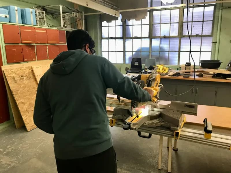 Someone using a chop saw to cut wood