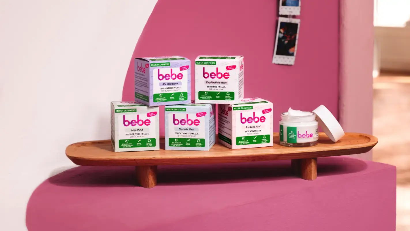 Verpackte Produkte der unterschiedlichen bebe Gesichtspflege liegen gestapelt auf einem Tablett. 