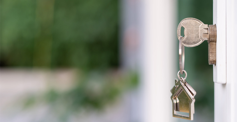 An image of a key inserted into the lock of a door.