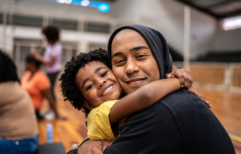 A father and son posing for a photo and hugging