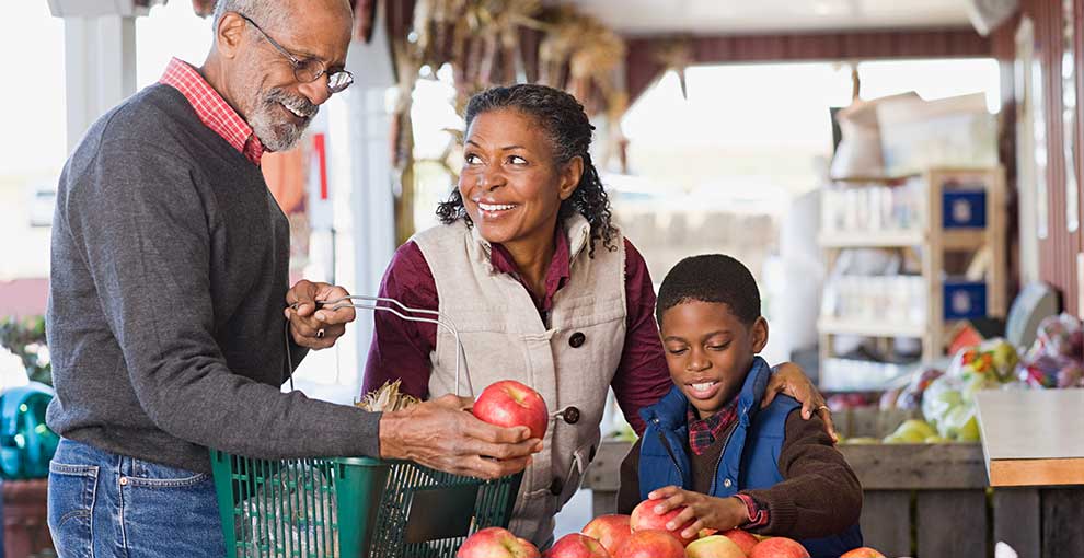 Grandparents shopping for fruit with their grandchild