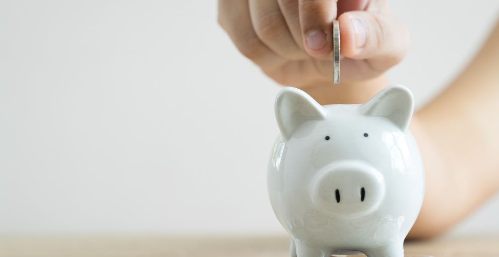 dropping a coin into a piggy bank