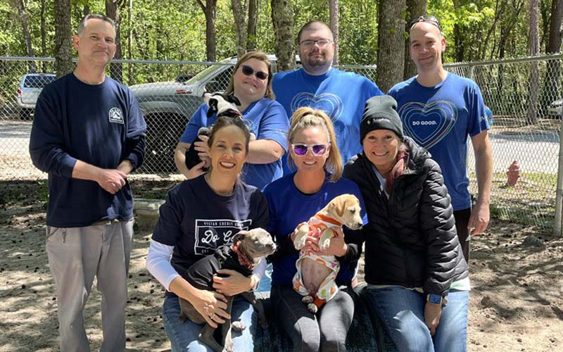 A photo of a group of VyStar employees posing for a photo outside at SAFE animal shelter