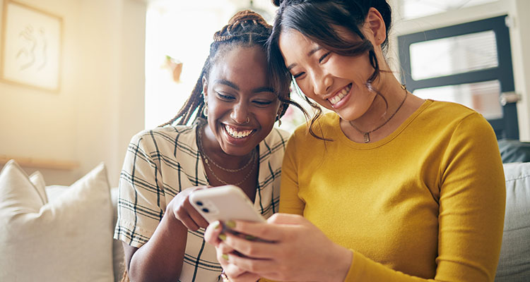 Two women on a couch looking at a phone