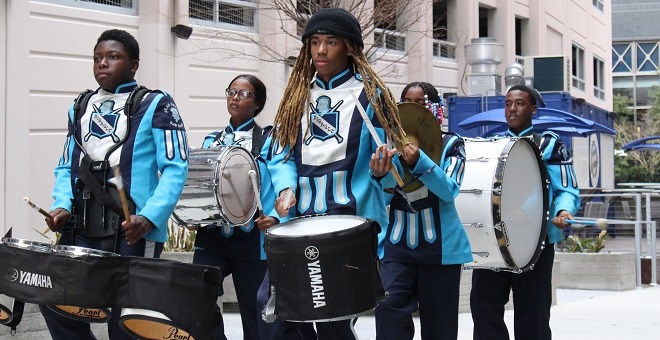 The Ribault drum line marches through the VyStar Breezeway.