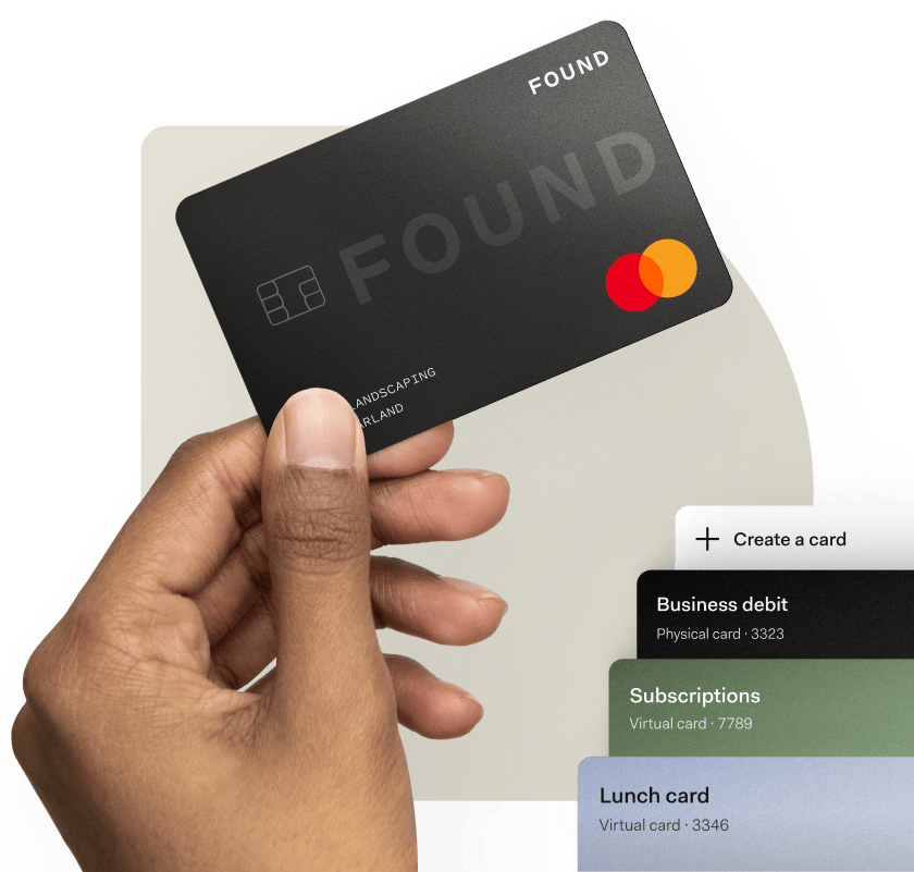 Hand holding a black Found debit card above a mobile app showing options to create virtual or physical business cards for business spending.