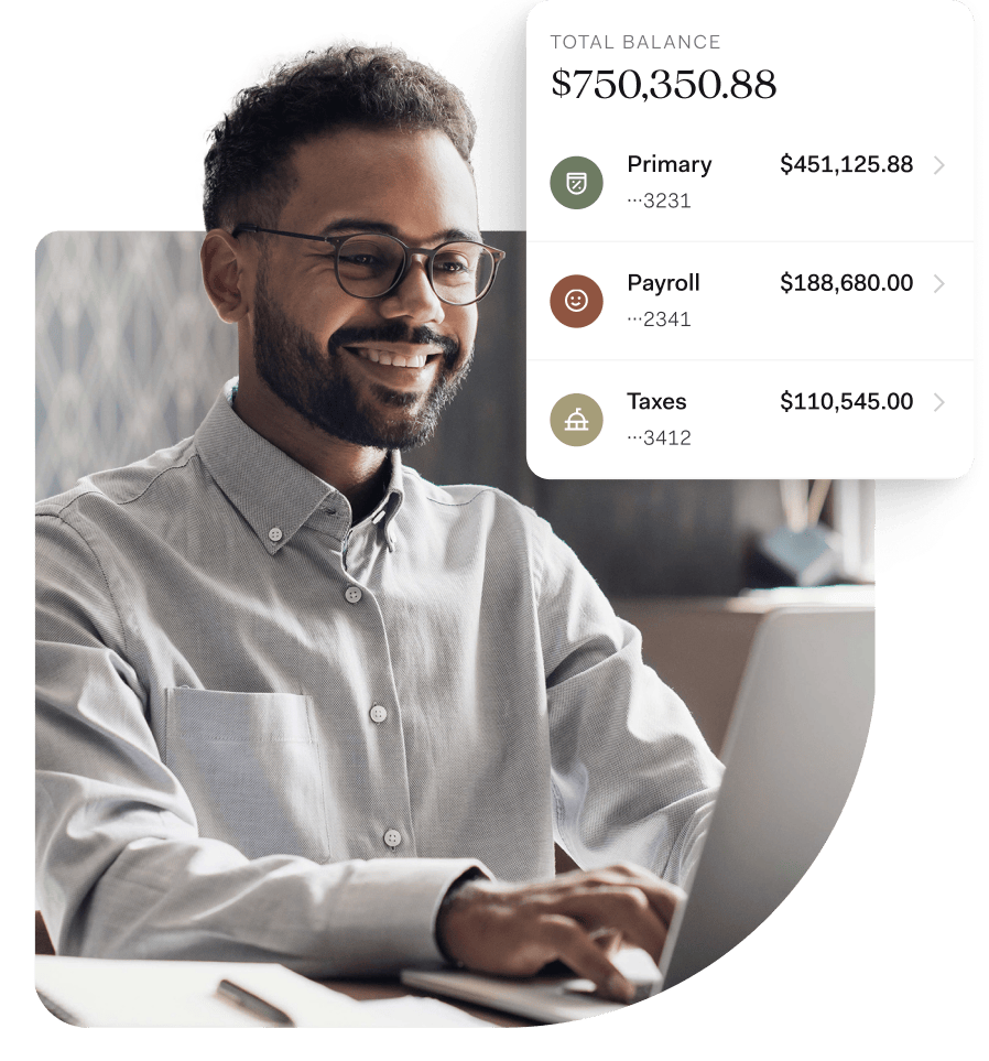 A smiling man with glasses types on a laptop in a home office setting. Overlaid on the image is a digital banking dashboard showing a total balance of $750,350.88, split across three labeled pockets: Primary ($451,125.88), Payroll ($188,680.00), and Taxes ($110,545.00). The interface highlights Found’s organized approach to managing business finances.