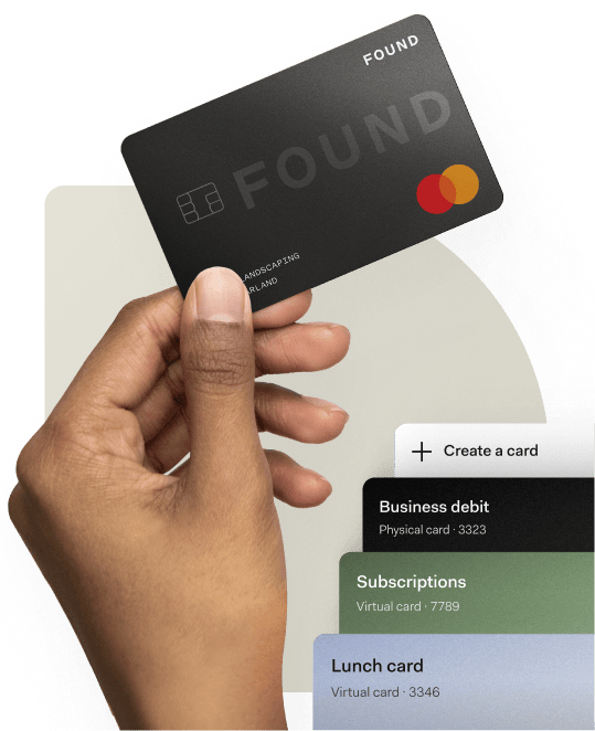 Hand holding a black Found debit card above a mobile app showing options to create virtual or physical business cards for business spending.