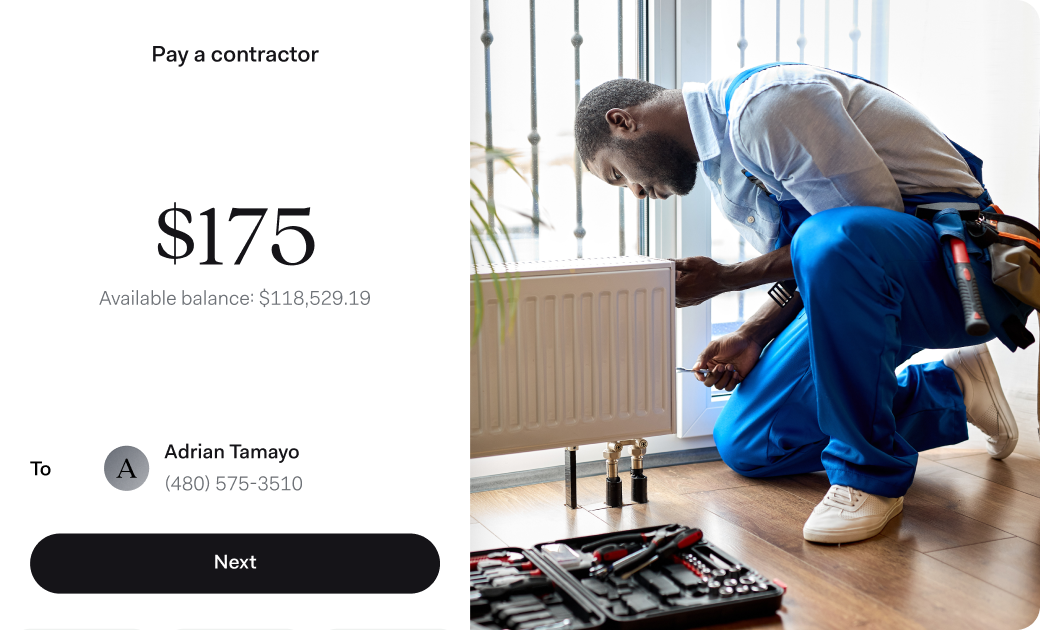 A technician in blue overalls kneels on the floor while working on a heating unit next to a window. On the left, a mobile screen shows a contractor payment interface with a $175 payment to Adrian Tamayo and a large available balance.