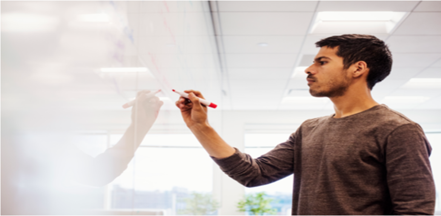 a man writing on a whiteboard