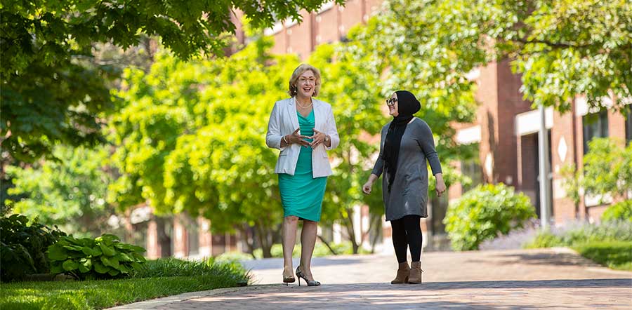 Two people walking along path in Lilly courtyard