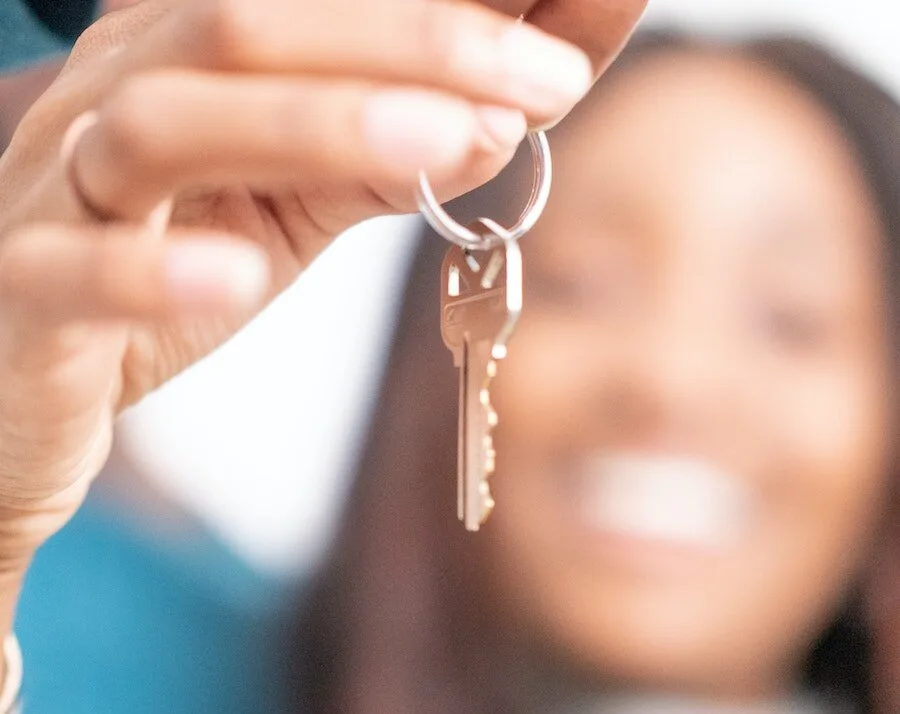 person danging a key on a keychain from their fingers