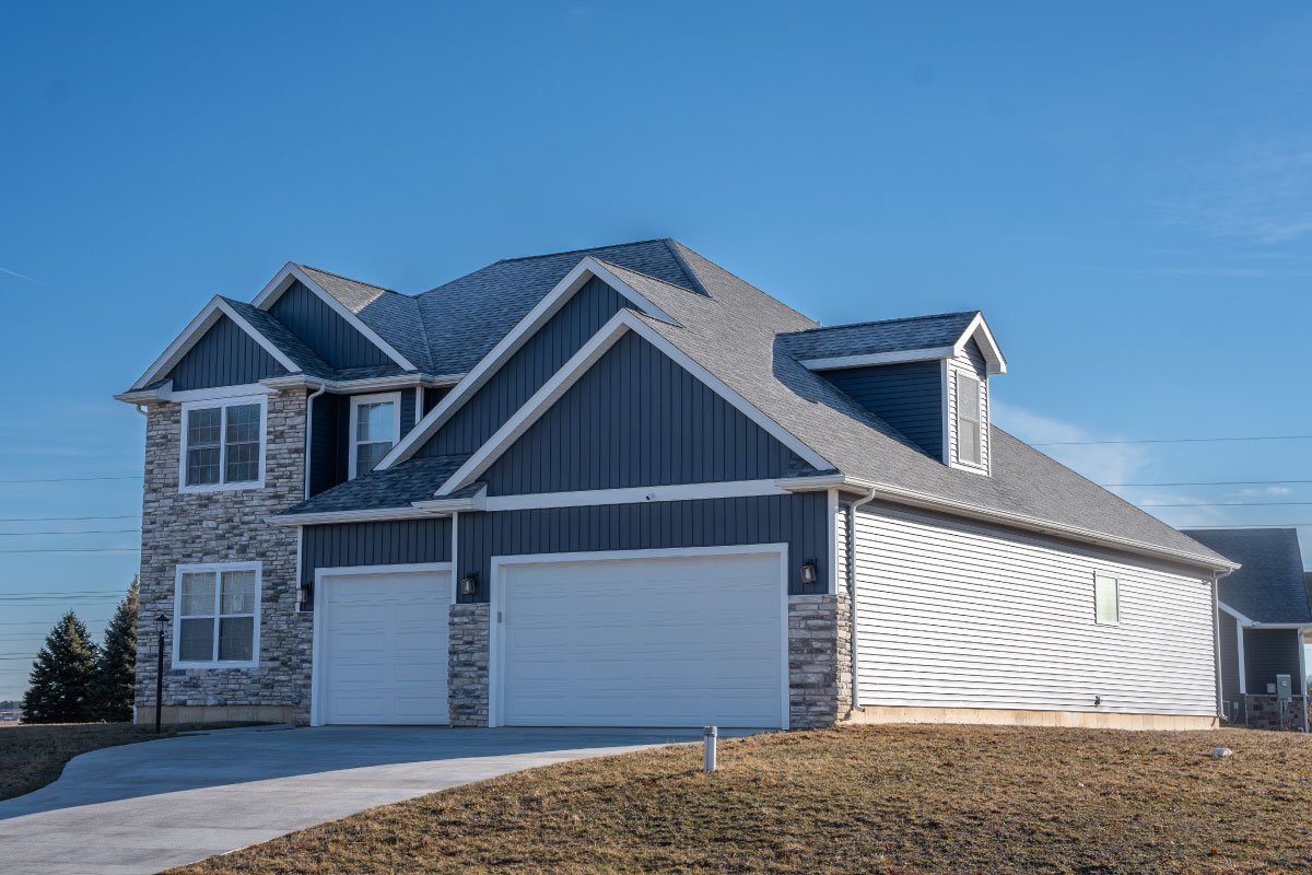 Two-story blue-gray home with stone accents and a three-car garage in Indiana