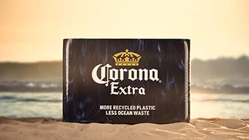 Corona bierkrat op het strand in het klein