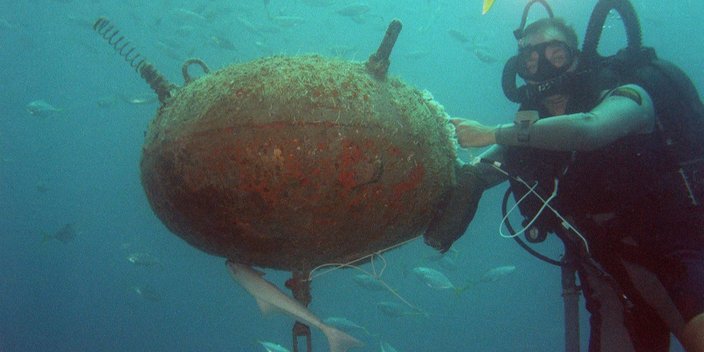 Diver inspecting moored naval mine