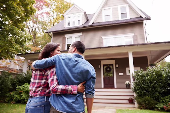 Couple standing in front of their house