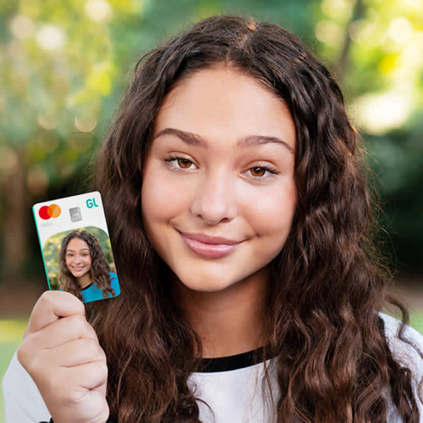 teen girl holding up her greenlight debit card