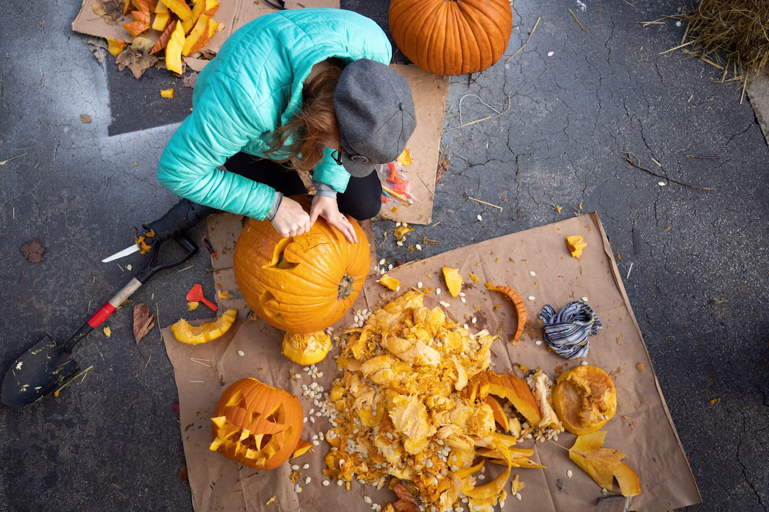 A woman carving a pumpkin outside.