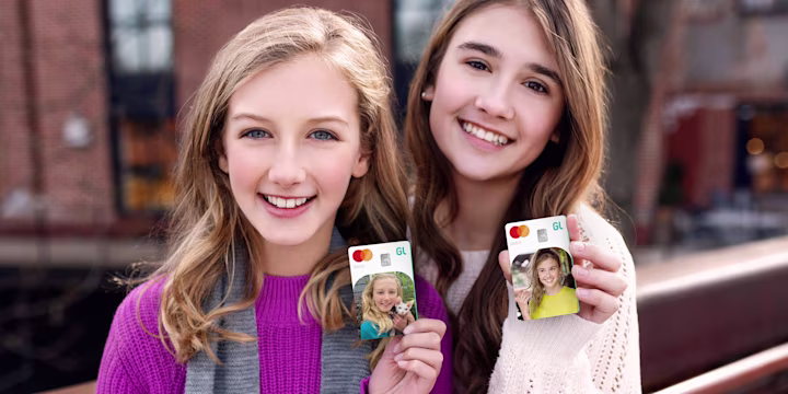 two young ladies holding greenlight custom debit cards