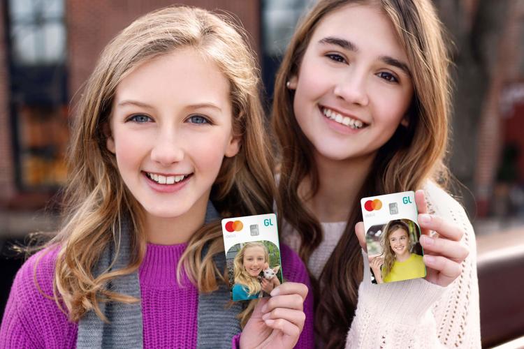 two young ladies holding greenlight custom debit cards