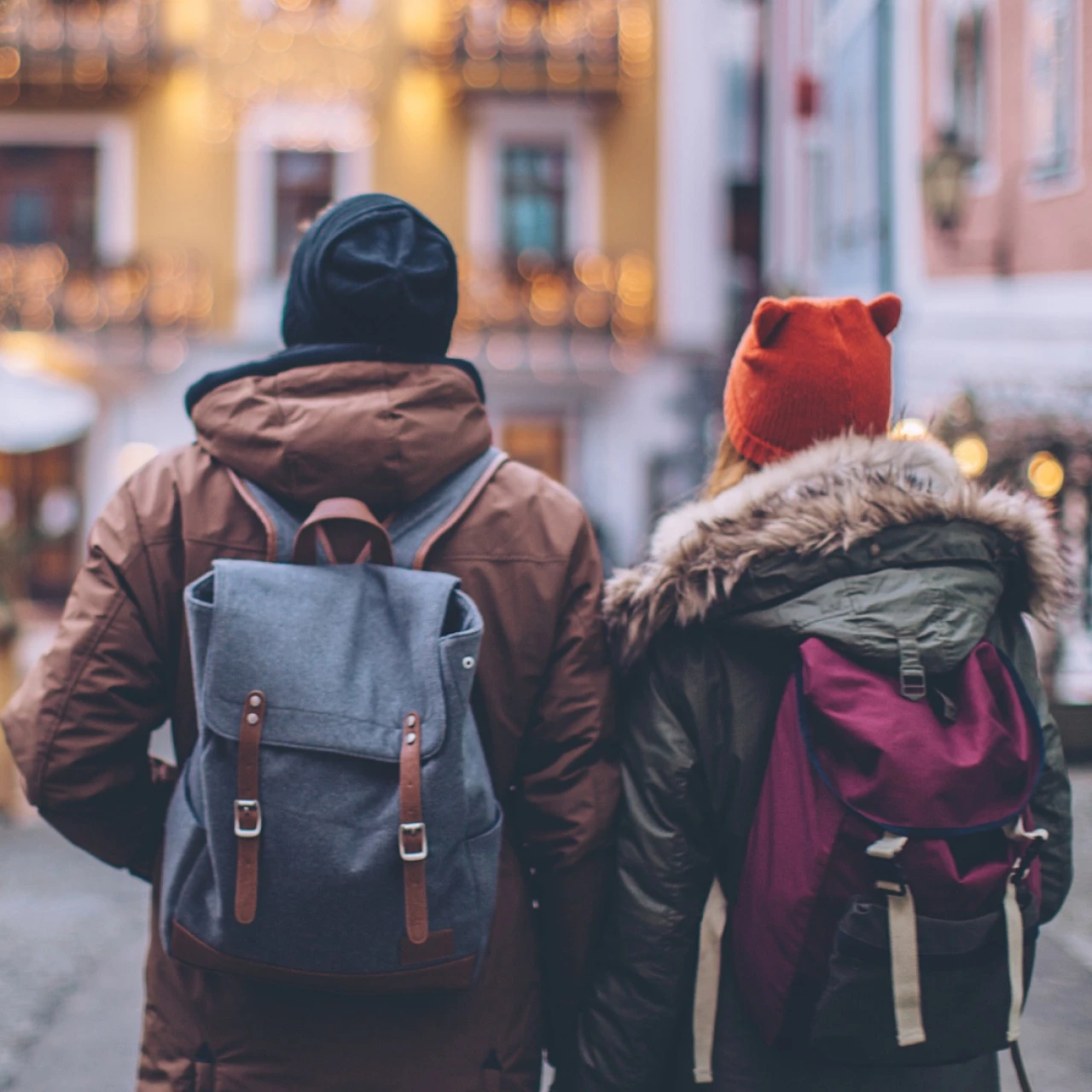 Couple traveling safely wearing backpacks and winter coats