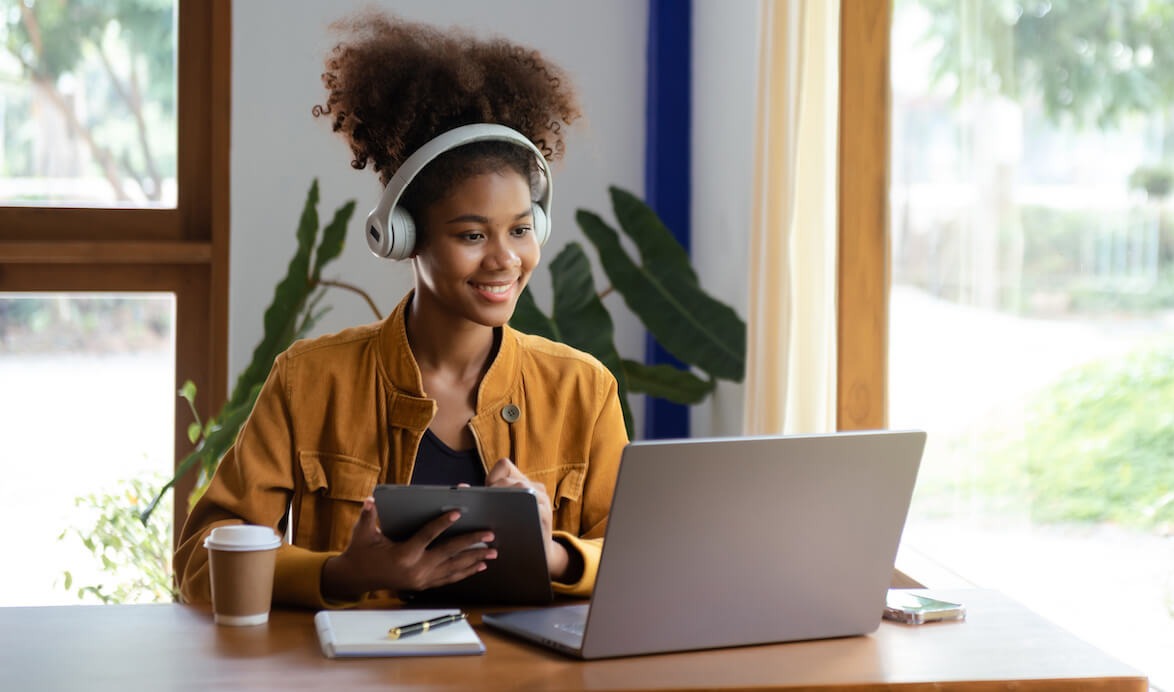 Zoom Interview Tips 13 Ways To Nail Your Video Interview   Woman Using A Tablet And Looking At A Laptop 