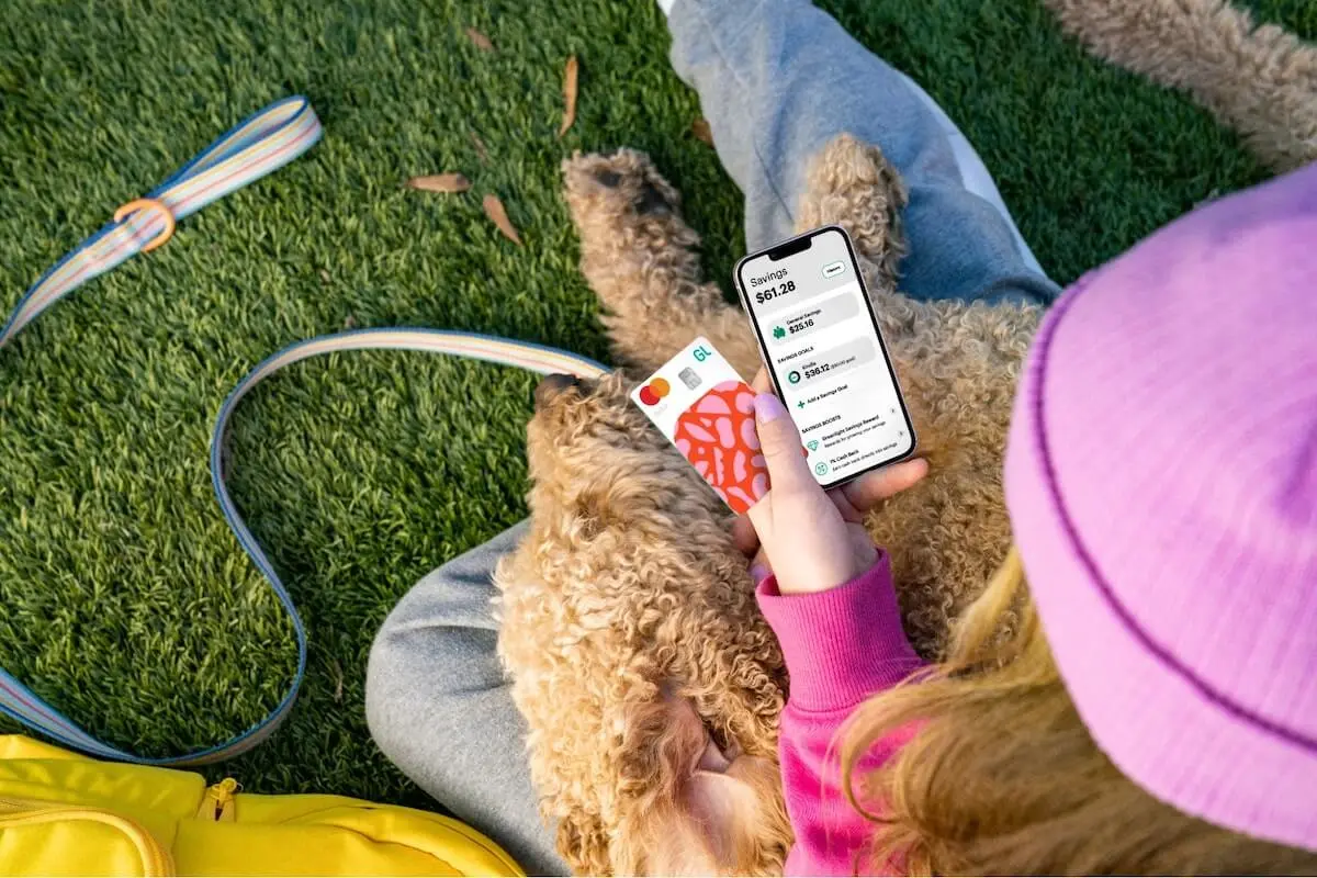 Person using her phone while her dog sleeps on her lap