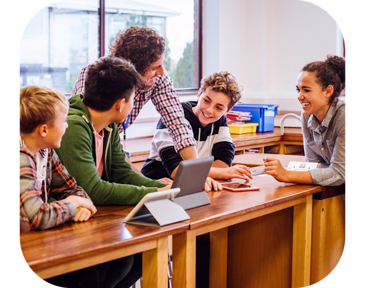 Teacher talking to students in a classroom.