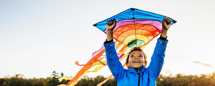 boy holding rainbow kite