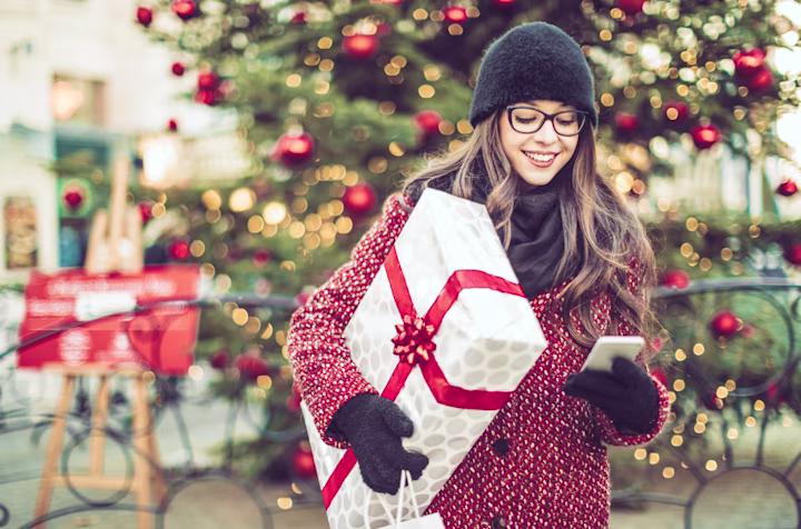 Teen girl looking at Greenlight app while shopping for the holidays to keep track of budget