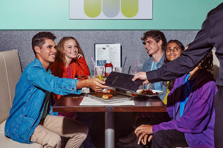Teens paying at table in restaurant