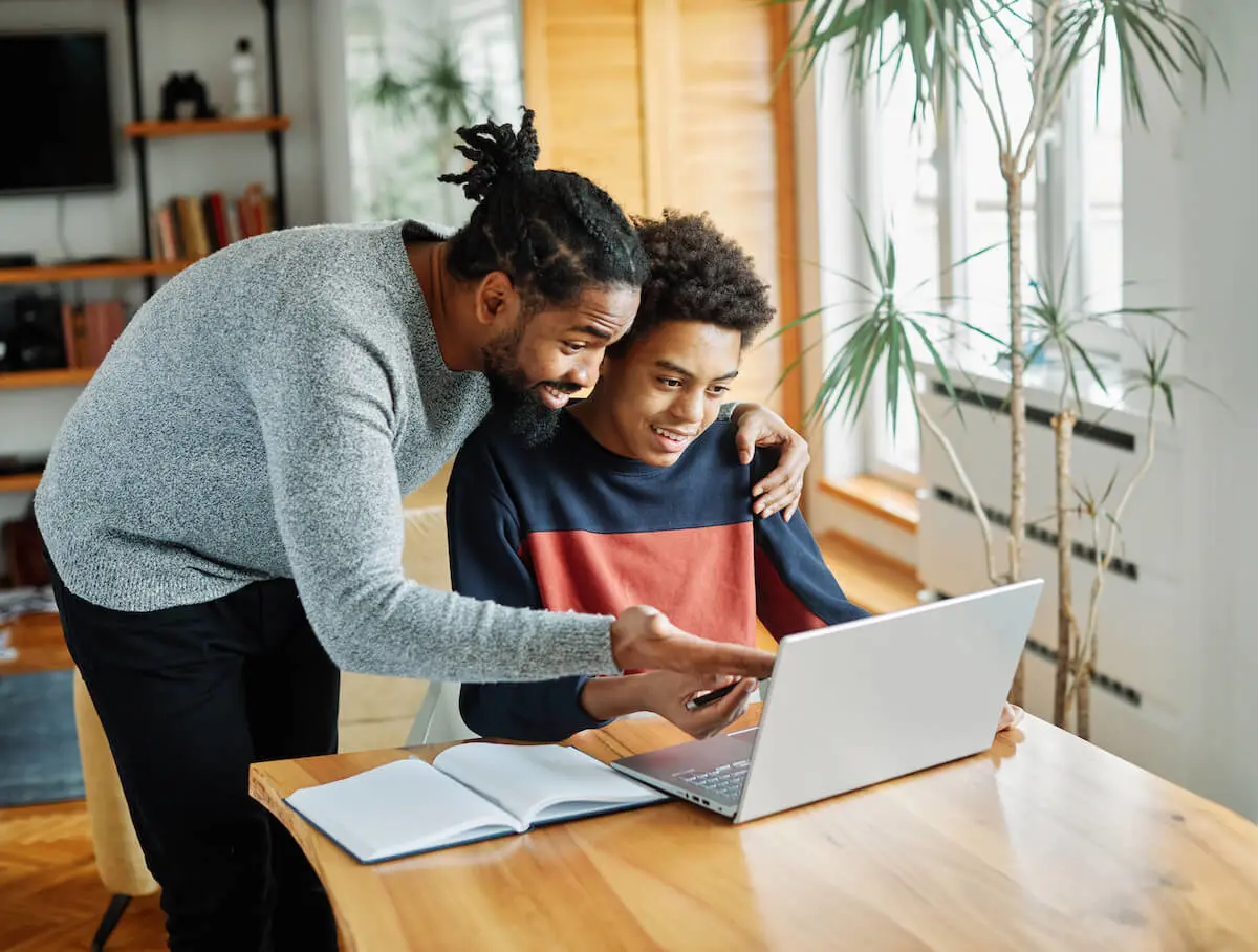 How to invest as a teenager: father and son using a laptop