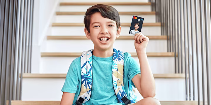 young boy holding his greenlight custom debit card
