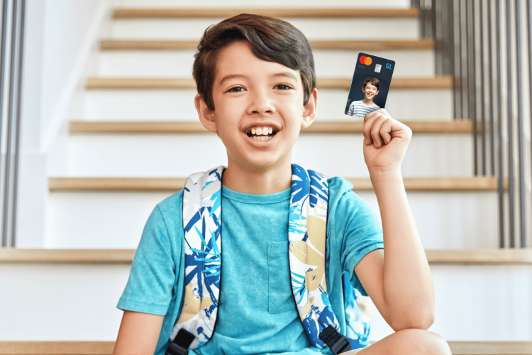young boy holding his greenlight custom debit card